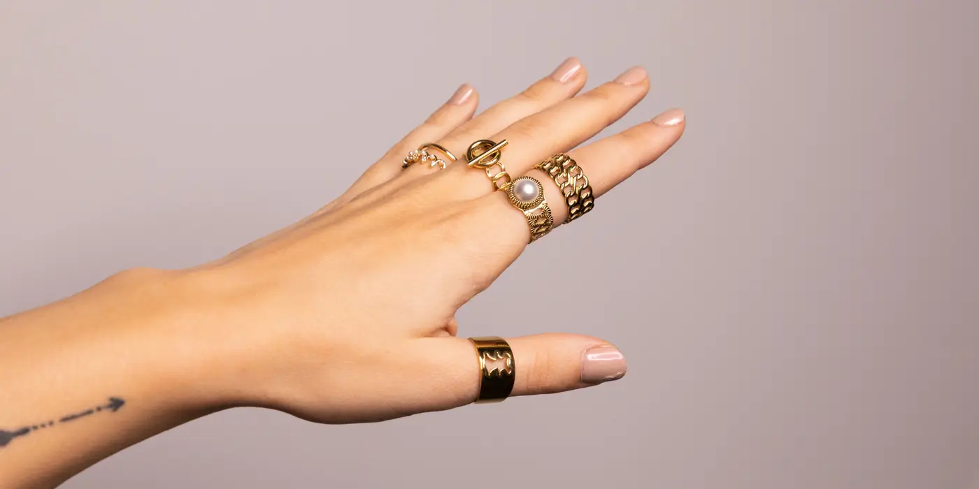 Kobieca ręka ze złotymi pierścionkami ze stali chirurgicznej – Elori